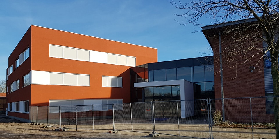 het-nieuwe-onderwijsgebouw-in-rood-stucwerk-als-knipoog-naar-de-voormalige-rooie-school
